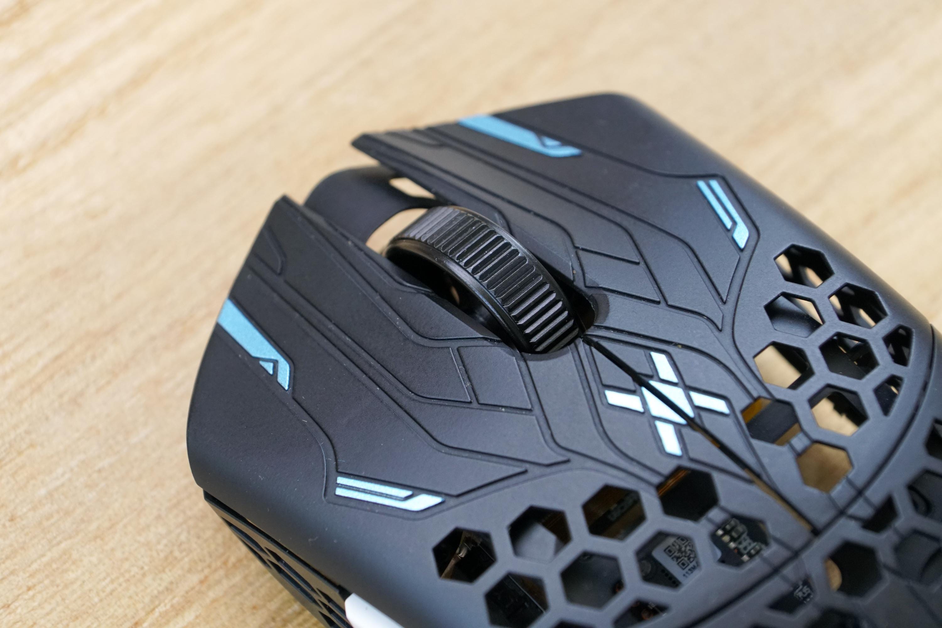 Close-up of the black Finalmouse ULX mouse shell with blue accents and honeycomb cutouts